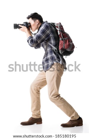 Asian young male backpacker take a picture, full length portrait isolated on white.