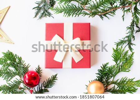 Christmas white background with Christmas tree and gift in a red box with a white bow. Top view