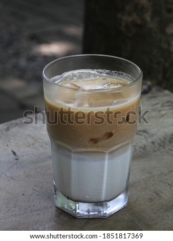 A glass of ice milk coffee with blurry background. selective focus