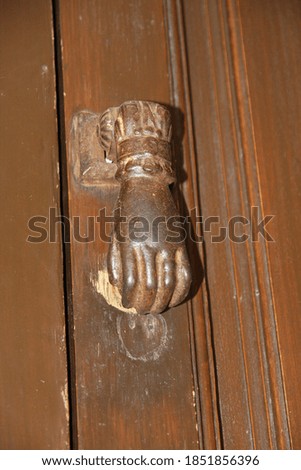 The rusty metal knocker on the old dilapidated wooden door, Cordoba.