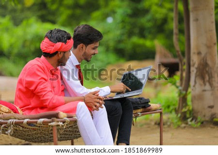 Young indian farmer and agronomist or banker discuss at home
