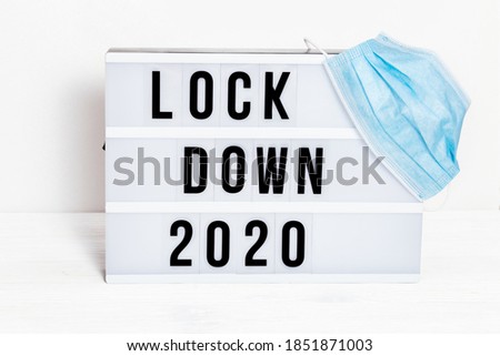 Light box with message lockdown 2020  and Surgical protective mask. Word of the Year 2020 is lockdown. Social media content.