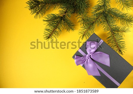 new year's Christmas background on top a branch of spruce pine trees on a bright yellow Sunny background with space for the text copy space