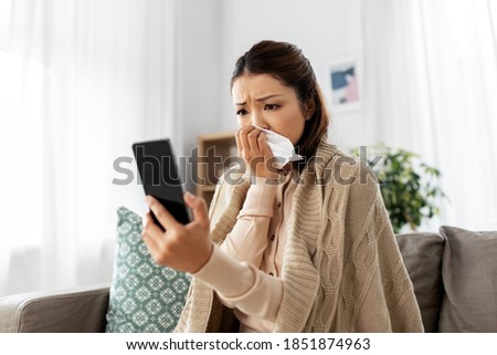 medicine, healthcare and technology concept - sick young asian woman having video call or online consultation on smartphone at home Royalty-Free Stock Photo #1851874963