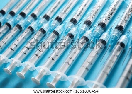 Close up of a group of syringes on a blue table. Royalty-Free Stock Photo #1851890464