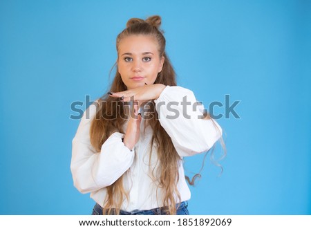 Young caucasian woman isolated on blue background showing a timeout gesture.