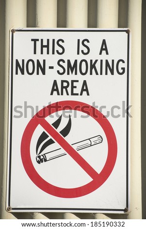 No smoking sign outside wall of building. Warning of health risk.