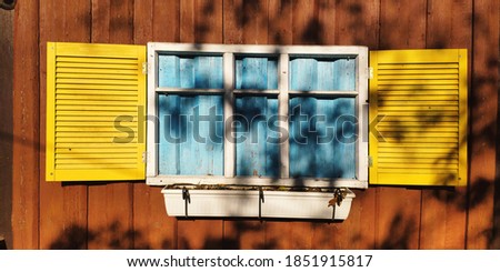 View of the window with yellow shutters