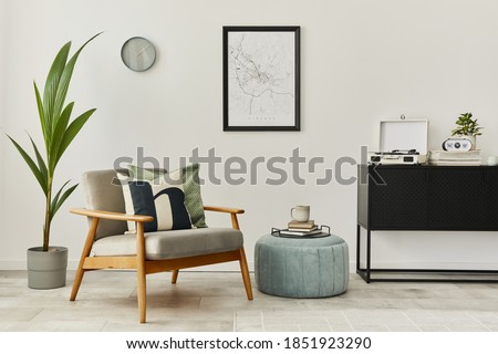 Modern retro concept of home interior with design grey armchair, coffee table, plants, mock up poster map, carpet and personal accessories. Stylish home decor of living room.