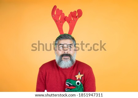 Portrait of man looking at horns head with interest wearing knitted bridge, isolated color background