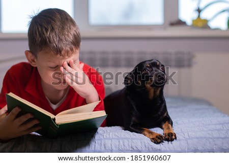 the Boy with dog reads a book