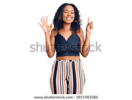 Young african american woman wearing casual clothes showing and pointing up with fingers number six while smiling confident and happy. 