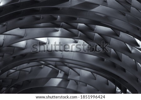Fragment of a structure made of concentrically arranged silver-colored metal plates with transverse elements. Futuristic abstract textured background. Interior design.
