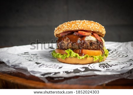 Tasty beef burger , potato chips on a wooden rustic board