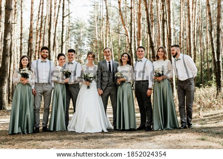 newlyweds with friends and friendships,witnesses at the wedding,wedding day of the bride and groom,cheerful groom with the bride and a group of witnesses are photographed in the forest,