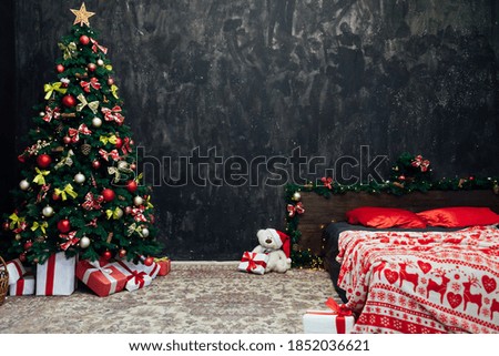 Christmas tree with red bedroom bed decor and gifts in the interior of the new year