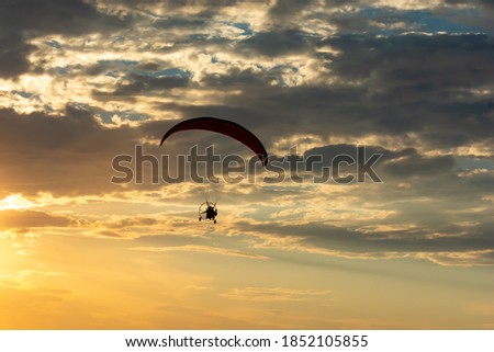 Paragliding. Paraglider flying in the sunset sky