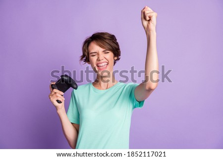 Photo of astonished young lady gamer wear casual teal outfit holding playing console isolated purple color background