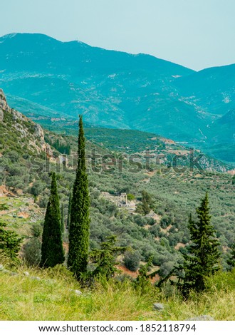 Vertical shot of mountainous landscapes in Delphi, Greece with the Tholos of Delphi