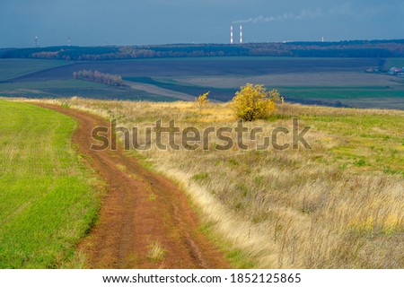 Autumn landscape photography. The European part of the land, fields, meadows, groves in autumn yellow tones. harsh gloomy gray sky in thick clouds