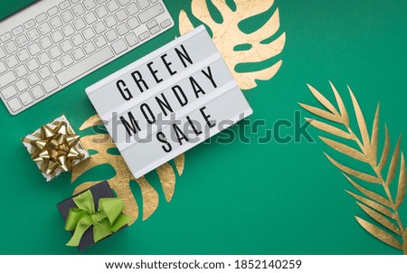 Green monday Sale text on Lightbox, keyboard, computer mouse, gift boxes, gold tropical leaves Monstera, green paper background. Singles day concept. Online shopping of China. Top view, copy space.
