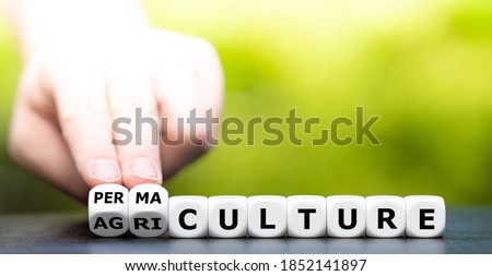 Hand turns dice and changes the word "agriculture" to "permaculture". Royalty-Free Stock Photo #1852141897