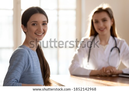 I recommend. Portrait of happy satisfied female patient customer of private clinic sitting at table in office of capable qualified woman doctor therapist or gynecologist smiling and looking at camera Royalty-Free Stock Photo #1852142968