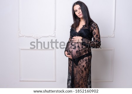 Pregnant girl in a black peignoir.