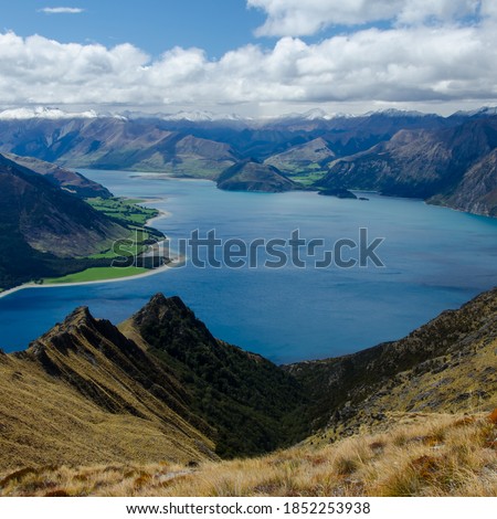 A vertical shot of the Isthmus Peak and a lake in New Zealand