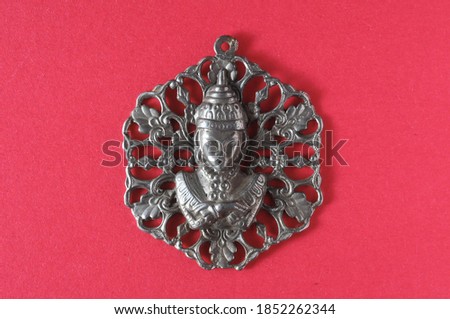 Silver Buddha Pendant Jewel over a Colored Background