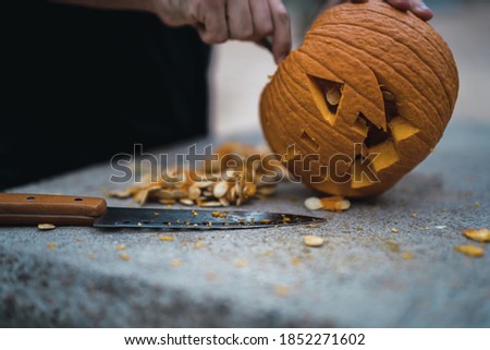 A man carving and preparing a pumpkin for Halloween