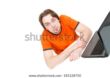 A young man sitting in front of a laptop, isolated on white 