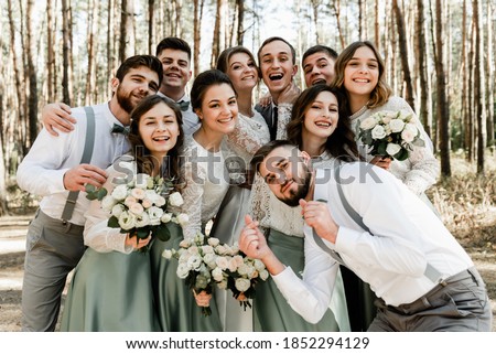 group of young people hugging tightly and laughing cheerfully,a group of friends celebrating a wedding day,lovely friendly family,witnesses and witnesses at the wedding
