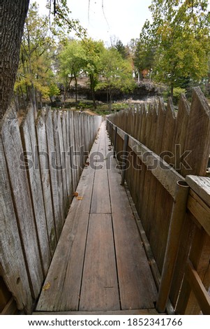 A wooden path surrounded by a wooden fence. Picture taken at the Blue Spring Heritage Center in Eureka Springs, Arkansas.
