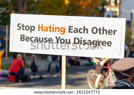 A message written on a banner placed in the street says: " Stop Hating Each Other Because You Disagree " . A peaceful slogan for tolerance to differing ideas and political views supporting harmony.