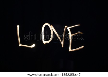 The word love painted with light using a long exposure
