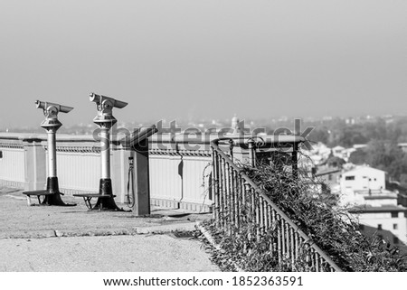 Telescopes for tourists aimed at the center of Florence from Piazzale Michelangelo which dominates the city from above. Black and white.