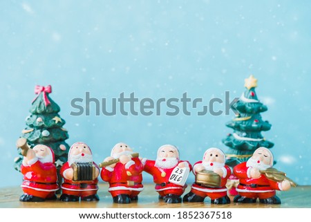 Santa claus sing a song on Christmas caroling day or Carolers singing with snows.Group Santa claus play music sing Christmas song on celebration of christmas day party in winter.Celebration Holidays.