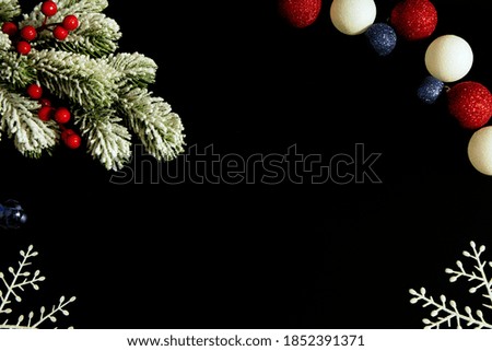 Christmas composition on black background made of snow tree with red berries, christmas balls and white snowflakes. Flat lay, top view, copy space.