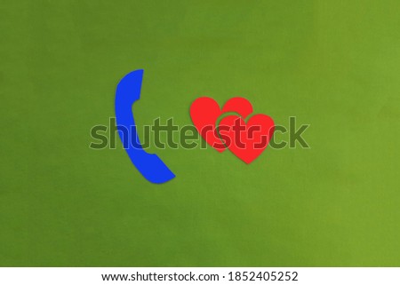 The handset is blue, two red hearts on a green background. Romantic communication, love, acquaintance.