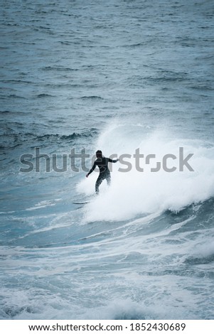 Man surfing on wave at manly beach in Sydney on cloudy rainy day