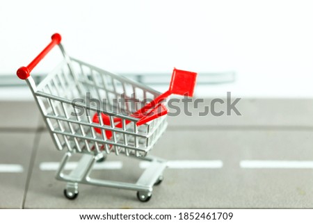 Miniature shopping cart model containing traffic signage pole model scene represent roadwork material online shopping concept related idea.
