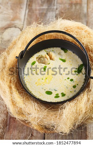 Cream soup with dumplings. Served on wooden table with straw