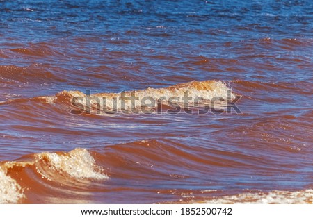 Waves on the surface of the river, red from dissolved clay (Background, banner, Wallpaper)