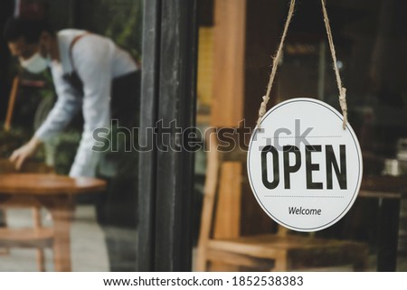 Reopen. coffee cafe shop text on vintage sign board hanging on glass door in modern cafe shop open after coronavirus quarantine is over in restaurant ready to service, small business owner concept