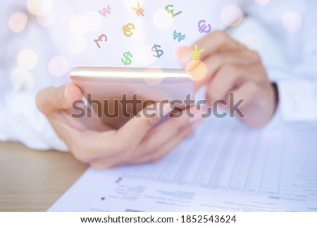 Close up using mobile with money symbol usd, euro, gbp, krw, cny on document for earning from online business. finance and technology in 2021 year concept. Royalty-Free Stock Photo #1852543624