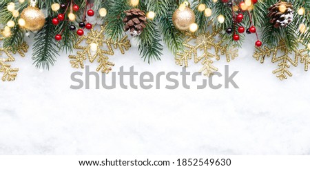 Christmas upper decoration with balls, snowflakes and cones on snow background.