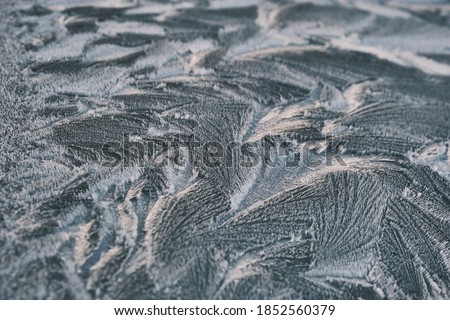 Frost drawing on window glass, snowflake ornament after anomaly ice cold. Blue top view. High quality photo