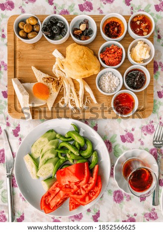 Top flatlay view of a traditional Turkish meal with strong tea, vegetables and other snacks and pickles for a rich middle eastern breakfast in the outdoor restaurant