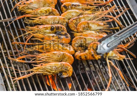 Closeup delicious prawns on charcoal grilled on fire.